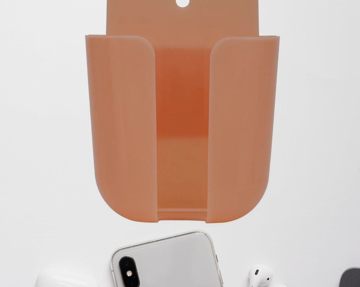Multicolour wall-mounted storage box for remotes and small items.