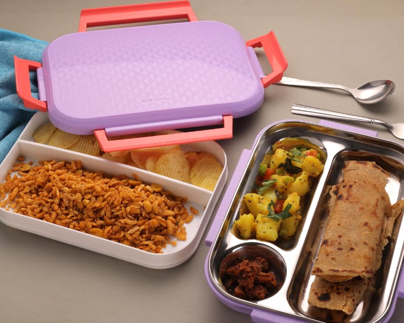 Multi-compartment lunch box with steel plates and a lid.
