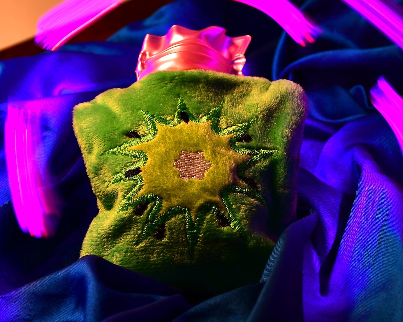 Green sun-shaped hot water bag with cover for pain relief