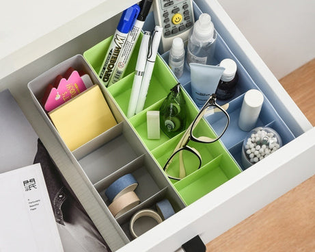 Clear plastic storage tray with dividers, used for organizing various small craft items.