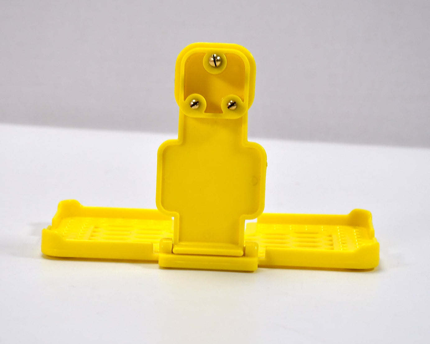 Yellow mobile holder for wall socket.