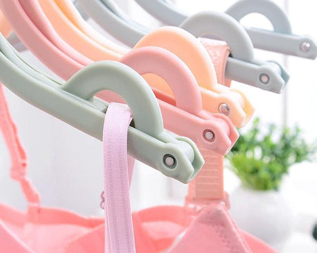 Foldable plastic hanger in vibrant colors, perfect for travel and organizing clothes.