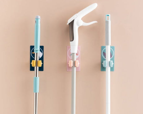 Self-adhesive mop and broom organizer for space-saving storage.