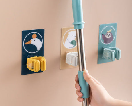 Self-adhesive wall mount for holding mops and brooms securely.