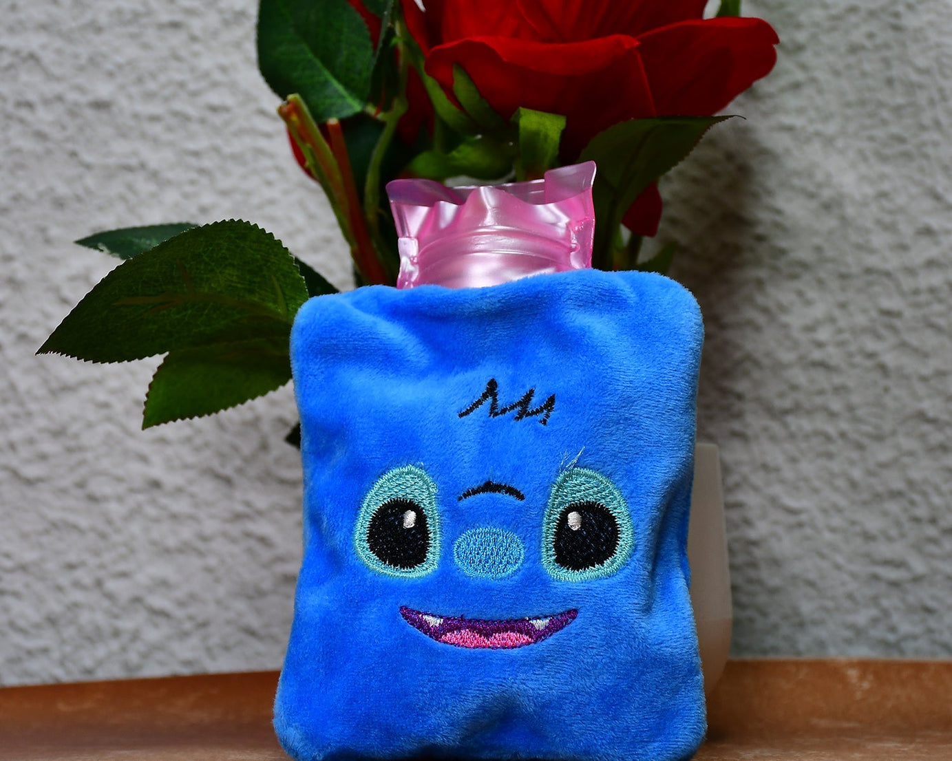 Small blue stitch hot water bag for menstrual cramps, neck, and shoulder pain